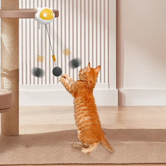 orange cat playing with automatic cat teaser ball attached to cat tree enrichment toy