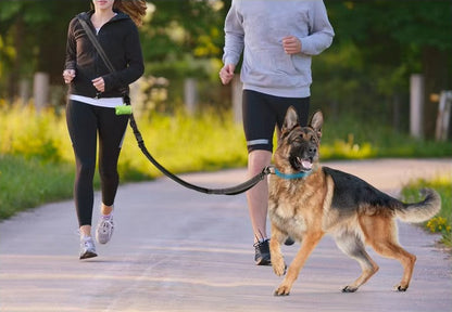 Woman using the 6-in-1 Multi-Use Hands-Free Dog Leash in shoulder carry mode while walking a German Shepherd in the park