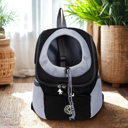 Black and gray pet carrier backpack on a wooden floor with plants in the background
