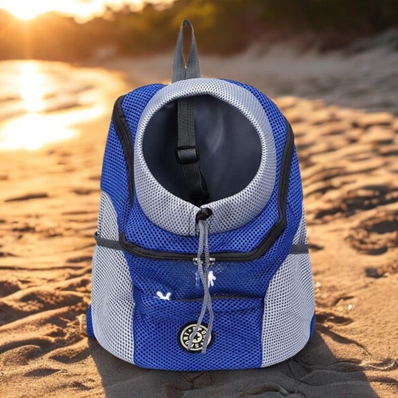 Blue and gray pet carrier on a sandy beach with sunset in the background