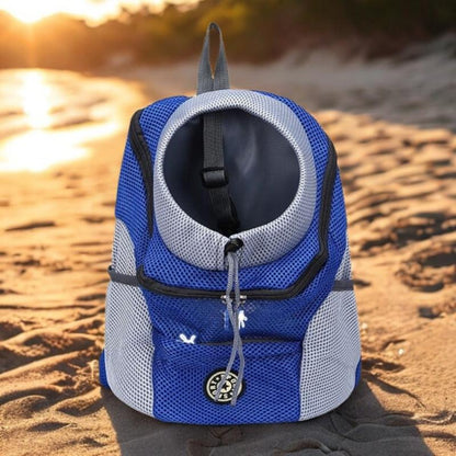 Blue and gray pet carrier on a sandy beach with sunset in the background