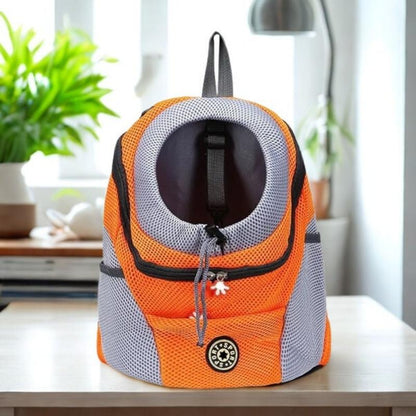Orange and grey pet carrier on a table with a plant in the background