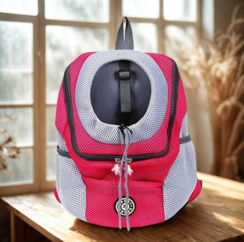 Red and grey pet carrier on a wooden table with a blurred background