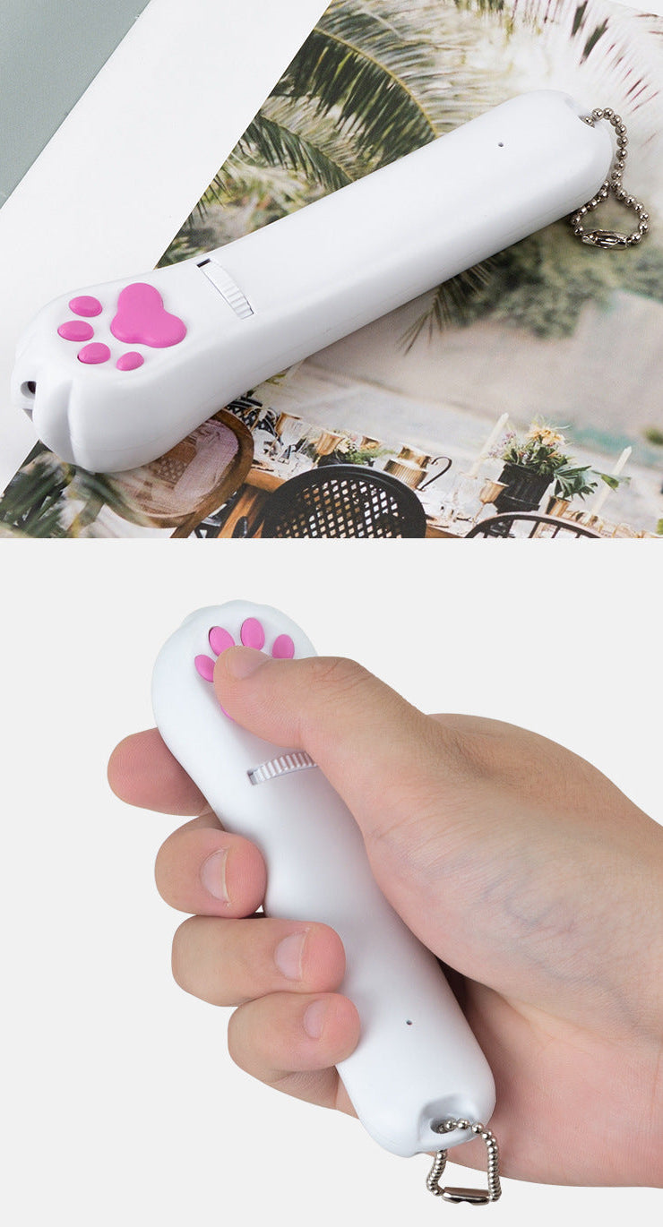 PawBeam with pink paw switch held by a hand on a white background