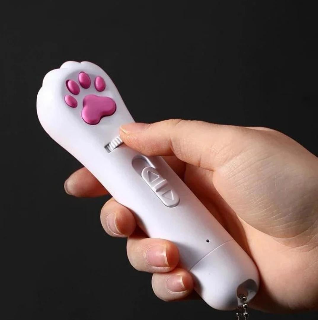Hand holding PawBeam Pro with a black background, with the thumb resting on the white control